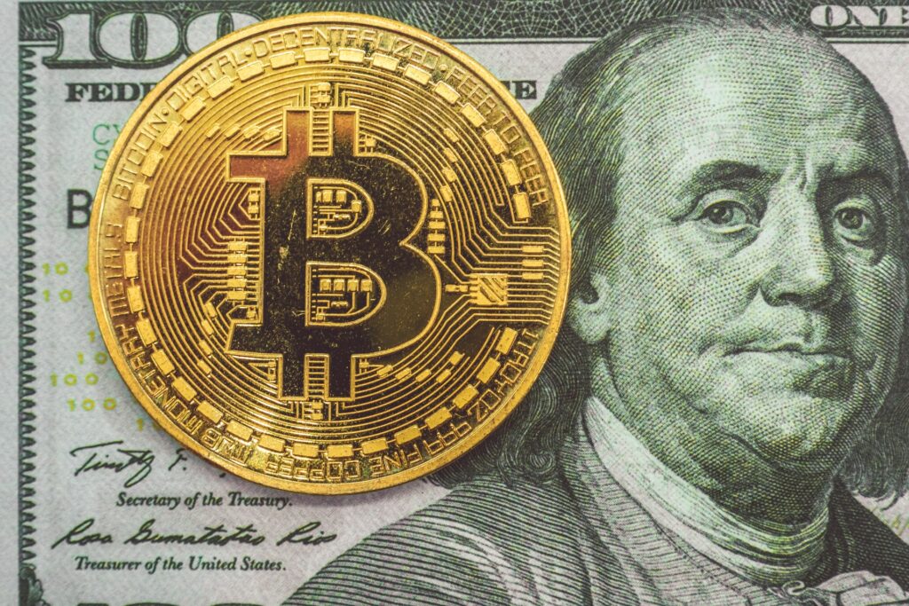 Illustration d'un billet de 100 dollars avec une pièce de bitcoin